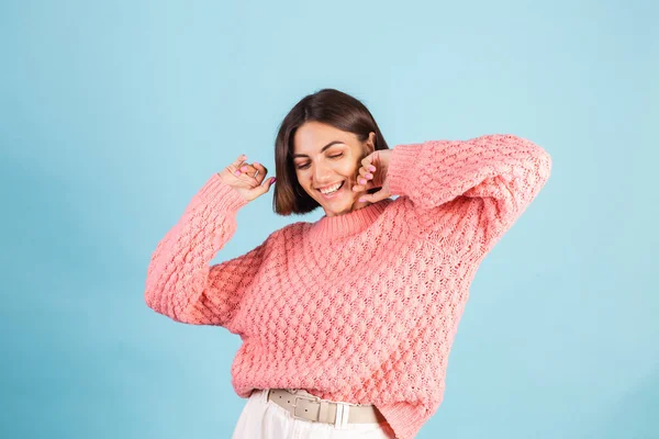 若いですブルネットで暖かいですピンクセーター隔離上の青背景幸せな正ダンスムービング — ストック写真