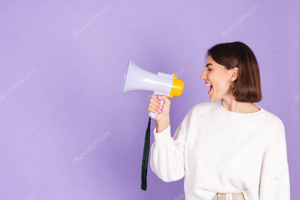 Young brunette in white casual sweater isolated on purple background happy screaming in megaphone copy space point left