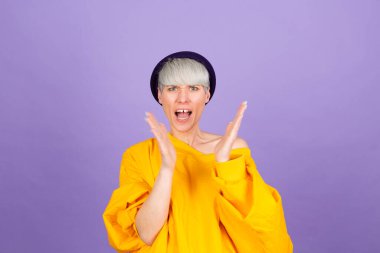 Mor arka planda şık Avrupalı kadın alkışlıyor ve mutlu ve neşeli, gururlu elleri alkışlıyor.