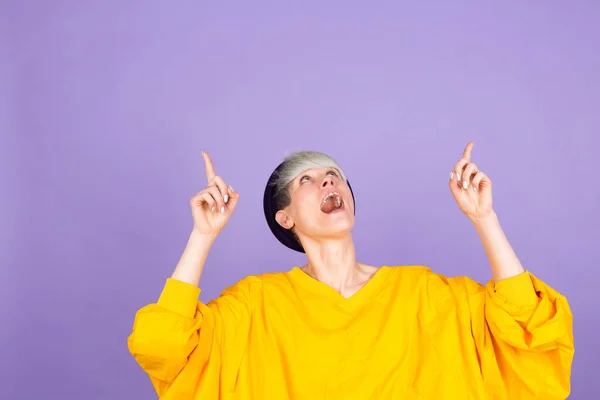 Стильная Европейская Женщина Фиолетовом Фоне Показывающая Пальцами Рекламу Удивленное Лицо — стоковое фото