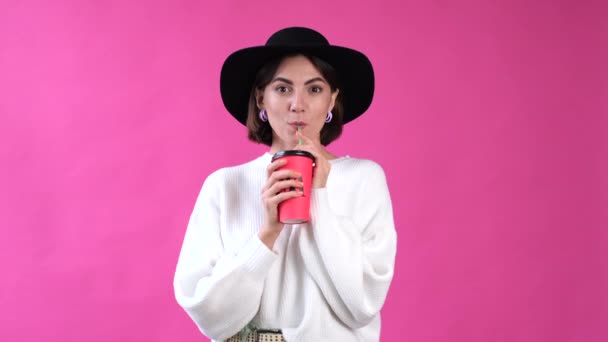 Γυναίκα Casual Λευκό Πουλόβερ Και Καπέλο Ροζ Φόντο Απομονωμένο Ποτό — Αρχείο Βίντεο