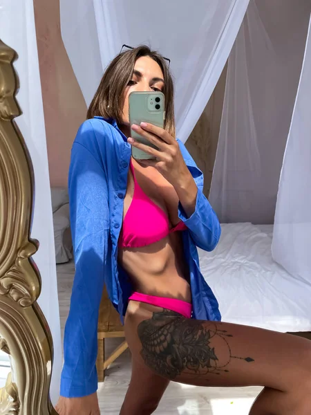 아가리 비키니를 엉덩이에 문신을 집에서는 미디어 이야기 개념을 전화로 사진을 — 스톡 사진