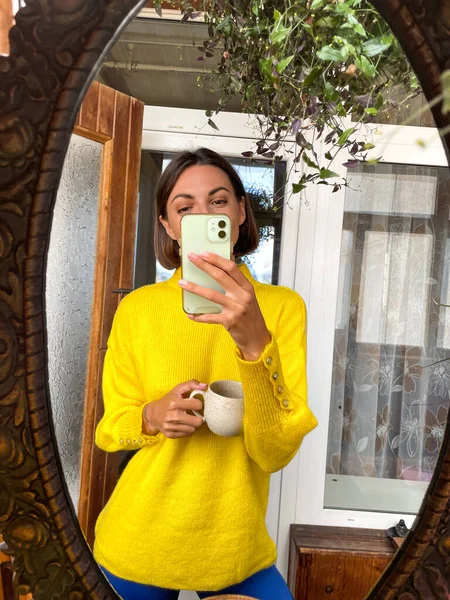 여자가 핸드폰으로 셀카를 미디어의 이야기와 게시물 프레임 아늑하고 노란색 스웨터를 — 스톡 사진