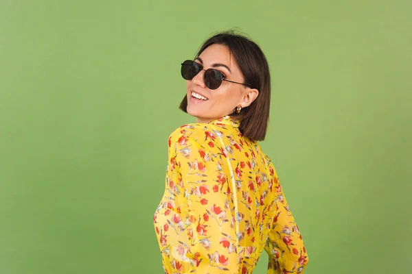 黄色の夏のドレスとサングラスの美しい女性 緑のスタジオの背景 幸せな正陽気な喜びの感情 — ストック写真
