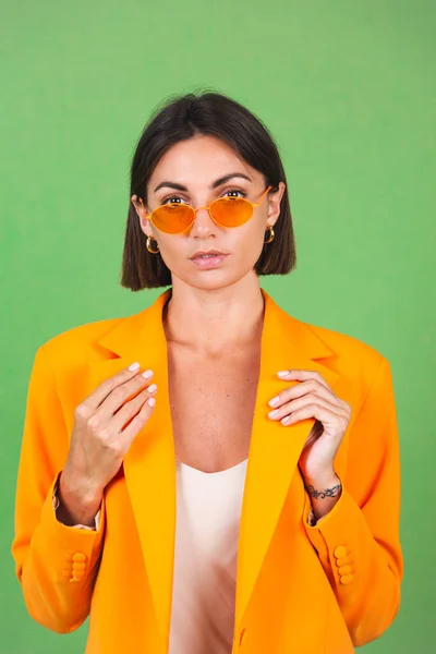 Stijlvolle Vrouw Zijde Beige Jurk Oranje Oversized Blazer Groene Achtergrond — Stockfoto