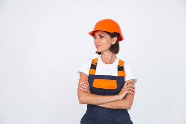 Beyaz arka planda koruyucu kask yapan güzel bir kadın mühendis. Kendine güvenen bir gülümseme.