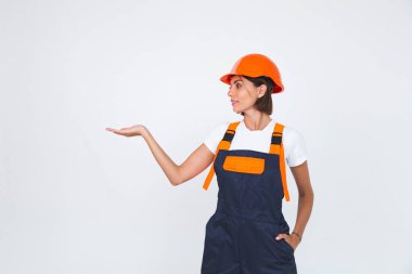 Beyaz arka planda koruyucu miğfer inşa eden güzel bir kadın mühendis. Kendine güvenen bir gülümseme.