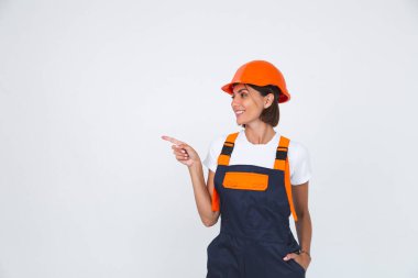 Beyaz arka planda koruyucu miğfer yapımında çalışan güzel kadın mühendis.