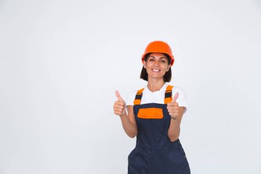 Beyaz arka planda koruyucu başlık takan güzel bir kadın mühendis. Kendine güvenen bir gülümseme.