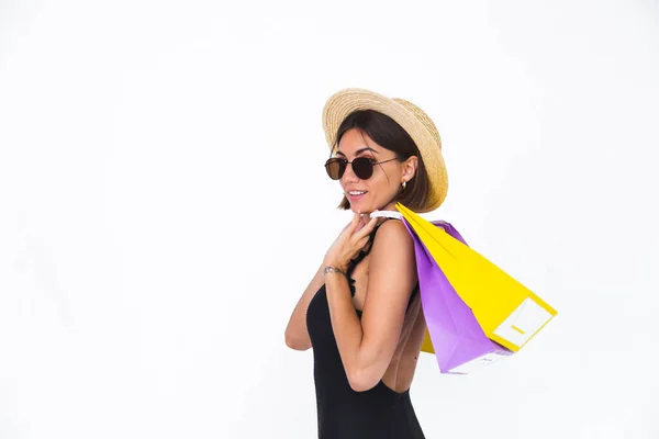 フィット日焼けした女性で黒水着サングラスと藁帽子上の白い背景ホールドショッピングバッグ幸せな正喜び — ストック写真