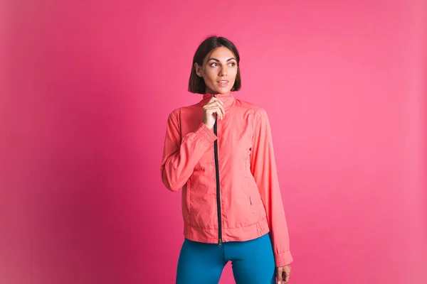 若いですフィット女性でスポーツウェアジャケット上のピンクの背景 — ストック写真