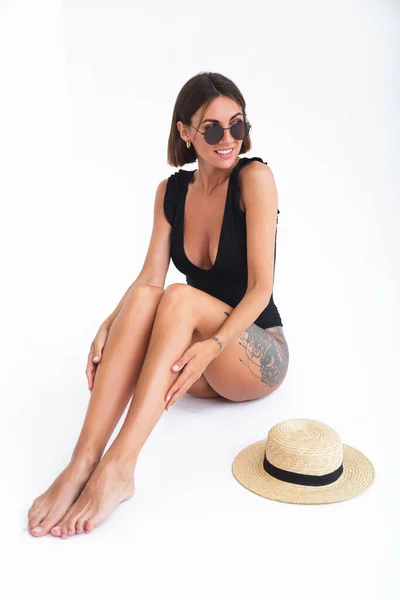 フィット日焼けした女性で黒水着サングラスと藁帽子上の白い背景ポージング 垂直フレーム — ストック写真