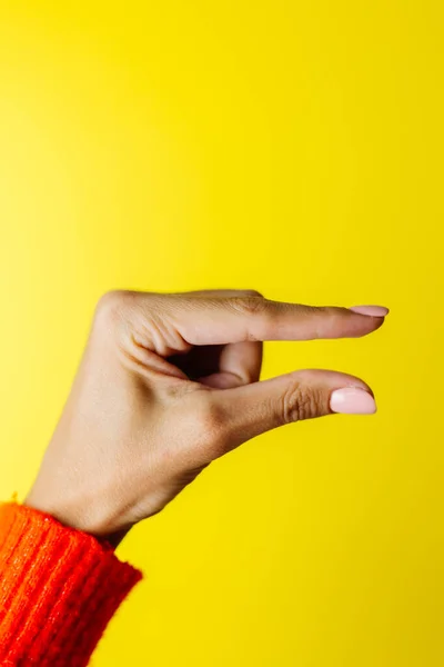 Mano Mujer Suéter Rojo Muestra Pequeño Gesto Sobre Fondo Amarillo —  Fotos de Stock