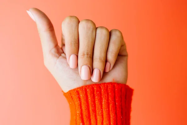 Woman Hand Red Sweater Shows Gentle Soft Pink Polish Manicure — Stock Photo, Image