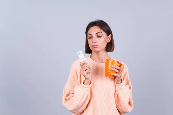 Mulher Suéter Fundo Cinza Detém Caneca Pílulas Com Expressão Triste — Fotografia de Stock