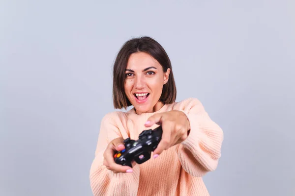 感情的な女性は灰色の背景にジョイスティックでゲームをプレイ — ストック写真