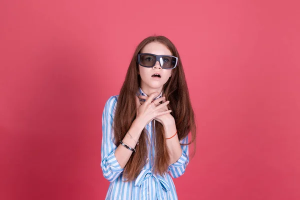 若いです女の子13歳で青ドレスともに角質隔離されたピンクの背景に身に着けています3Dシネマグラスショックを受けました — ストック写真