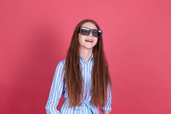 若いです女の子13歳で青ドレスともに角質隔離されたピンクの背景に身に着けています3D映画の眼鏡幸せな笑顔笑い — ストック写真