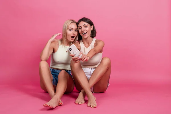 Две Девушки Друзья Случайном Розовом Фоне Сделать Фото Селфи Мобильный — стоковое фото