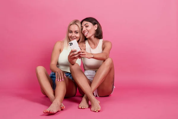 Due Amiche Casual Sfondo Rosa Scattare Foto Selfie Sul Telefono — Foto Stock