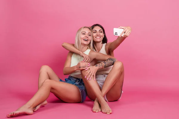 Duas Amigas Casual Fundo Rosa Tirar Foto Selfie Celular Gostando — Fotografia de Stock