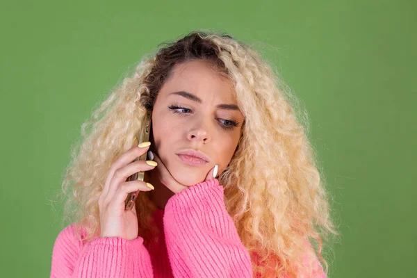 Vrouw Roze Trui Groene Achtergrond Houden Mobiele Telefoon Doordacht — Stockfoto