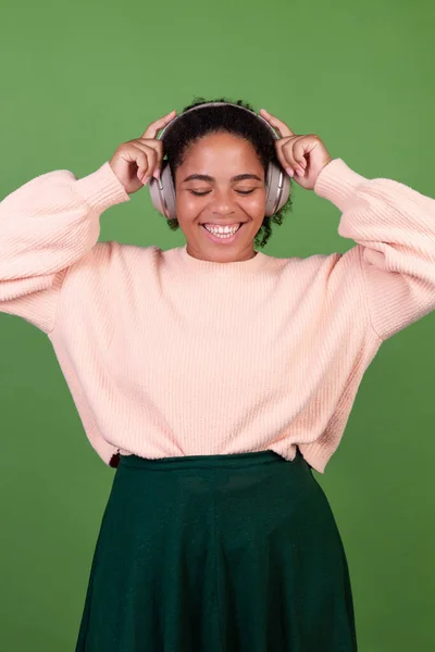 Yeşil Arka Planda Kablosuz Kulaklıklı Kendine Güvenen Güzel Afro Amerikan — Stok fotoğraf