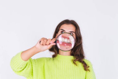 Beyaz arka planda, çilli, hafif makyajlı, beyaz dişli genç bir kadın mükemmel bir gülümseme sergiliyor.