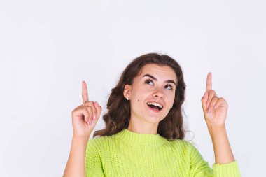 Çilli, hafif makyajlı, beyaz arka planda mutlu, neşeli, neşeli, gösterişli parmakları olan genç bir kadın.