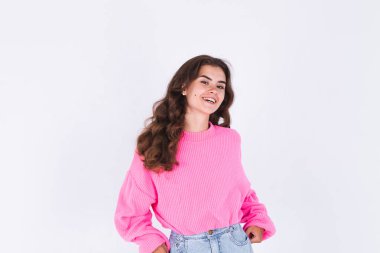 Çilli, hafif makyajlı, beyaz arka planda neşeli, mutlu, mutlu gülümseyen genç bir kadın.