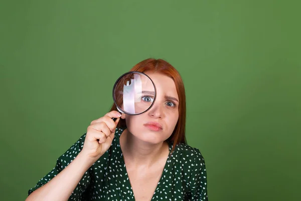 Young Red Hair Woman Green Background Magnifier Searching Serious Focused — Stock Photo, Image