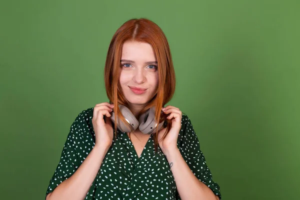 Young Red Hair Woman Green Background Wireless Headphones Look Camera — Stock Photo, Image