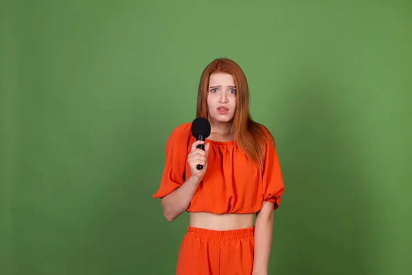 Νεαρή Κόκκινα Μαλλιά Γυναίκα Casual Πορτοκαλί Μπλούζα Πράσινο Φόντο Κρατώντας — Φωτογραφία Αρχείου