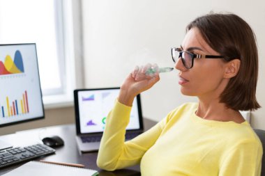 Kafkasyalı danışman finansal iş analisti. Veri gösterge paneli grafikleri olan kadın. Elektronik sigara içiyor.