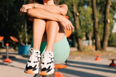 Spor ayakkabılı kadın bacaklarının yakın plan çekimi. Gün batımı ışığı.