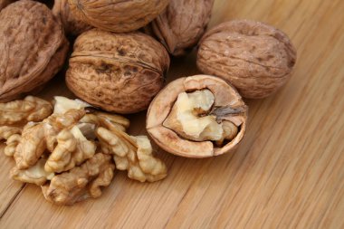 Ahşap arka planda tam ve kırılmış cevizler..