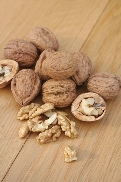 Ahşap arka planda tam ve kırılmış cevizler..