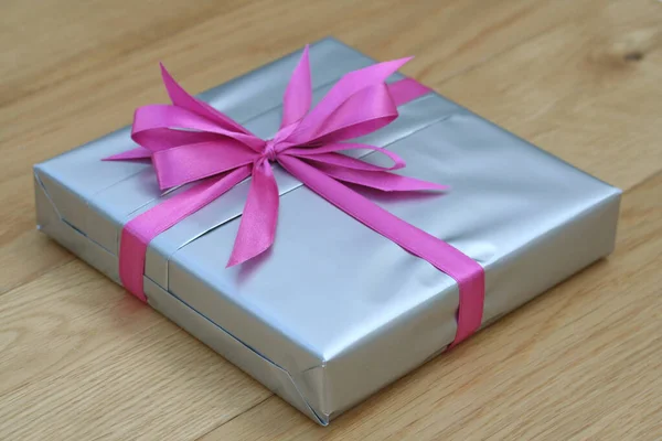 Coffret Cadeau Argent Avec Noeud Noué Rose Sur Table Bois — Photo