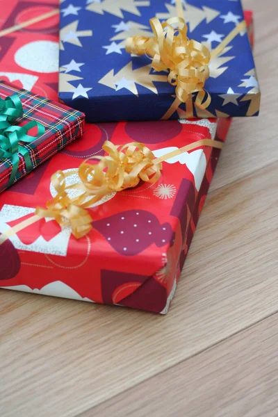 木製の背景にクリスマスのための黄金と緑のリボンとカラフルなギフトボックス — ストック写真