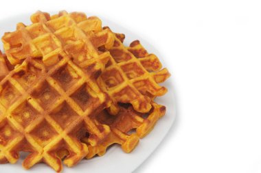 Beyaz arka bahçede izole edilmiş bir tabakta taze pişmiş waffle. Belçika tatlı yemekleri