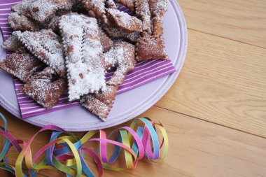 İtalyan Karnaval hamur işlerinin adı Crostoli ya da Cenci. Tahta bir tabakta. Geleneksel çikolatalı Crostoli 