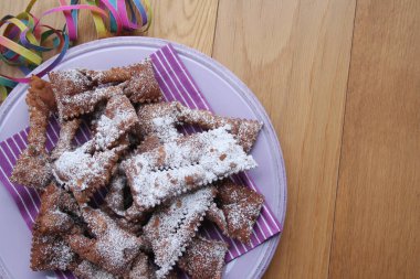 İtalyan Karnaval hamur işlerinin adı Crostoli ya da Cenci. Tahta bir tabakta. Geleneksel çikolatalı Crostoli 