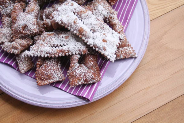 İtalyan Karnaval hamur işlerinin adı Crostoli ya da Cenci. Tahta bir tabakta. Geleneksel çikolatalı Crostoli 