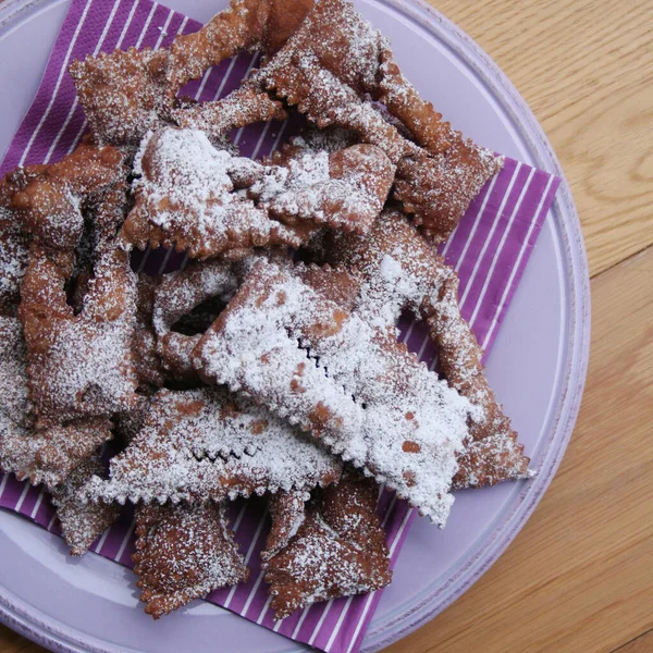İtalyan Karnaval hamur işlerinin adı Crostoli ya da Cenci. Tahta bir tabakta. Geleneksel çikolatalı Crostoli 