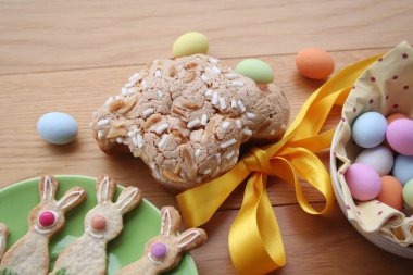 Paskalya pastası, adı Colomba Pasquale. Paskalya yumurtaları ve süslü kurabiyelerle birlikte. İtalyan geleneksel pastası ahşap masada.