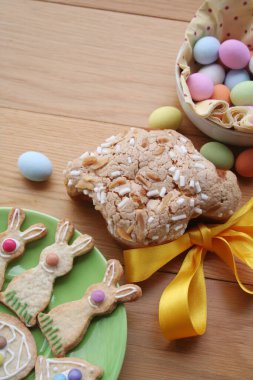 Paskalya pastası, adı Colomba Pasquale. Paskalya yumurtaları ve süslü kurabiyelerle birlikte. İtalyan geleneksel pastası ahşap masada.