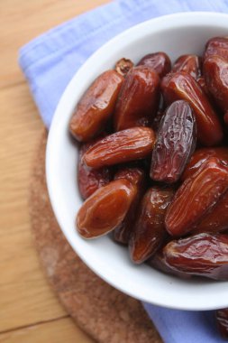 Ahşap arka planda kurutulmuş hurma kasesi 