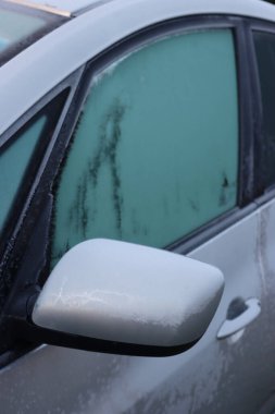 Gri araba kış mevsiminde donla kaplı. Seçici odak noktasında arabanın yan görünümü