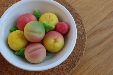 Geleneksel İtalyan badem ezmesi meyveleri ahşap masada bir kasede. Sicilya meyvesi şeklinde tatlı badem ezmesi