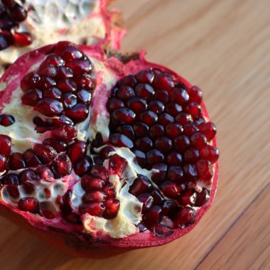 Tahta bir masada ikiye bölünmüş nar meyvesi. Punica granatum meyveleri